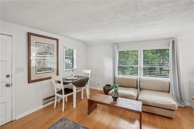 25 Standish Ave NW, Atlanta, GA 30309 - living room with a textured ceiling, light wood finished floors, baseboards, and a baseboard radiator