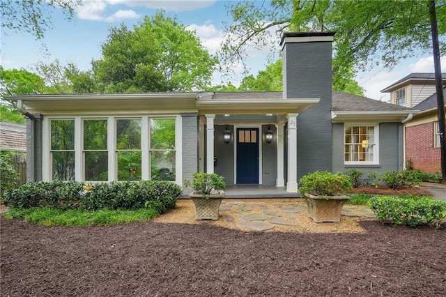 25 Standish Ave NW, Atlanta, GA 30309 - view of front facade featuring a chimney, brick siding, and covered porch