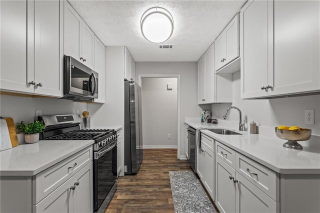 3833 Paddington Trl, Rex, GA 30273 - kitchen with appliances with stainless steel finishes, dark wood-style flooring, light countertops, white cabinets, and a textured ceiling