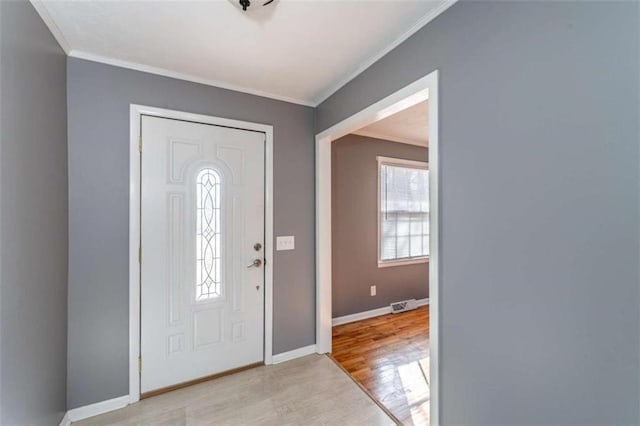 entrance foyer with light wood-type flooring, a wealth of natural light, and crown molding