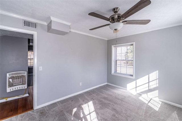 carpeted empty room featuring heating unit, ceiling fan, and crown molding