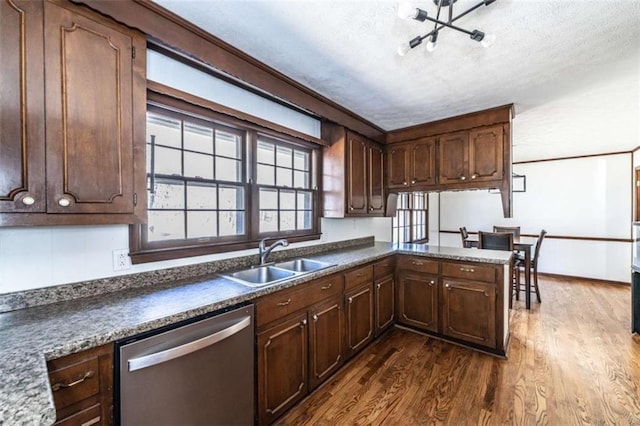 kitchen featuring a textured ceiling, dishwasher, dark hardwood / wood-style flooring, and sink