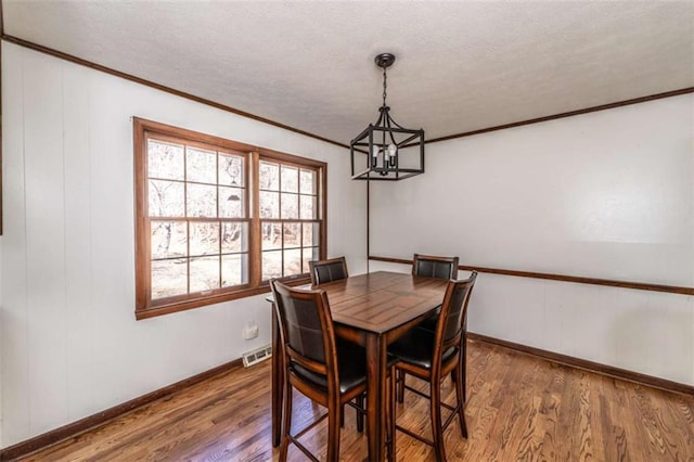 dining room with dark wood-type flooring and a chandelier