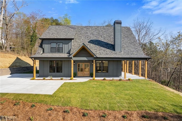 6371 Falcon Ln, Gainesville, GA 30506 - back of house featuring board and batten siding, roof with shingles, a yard, and a chimney