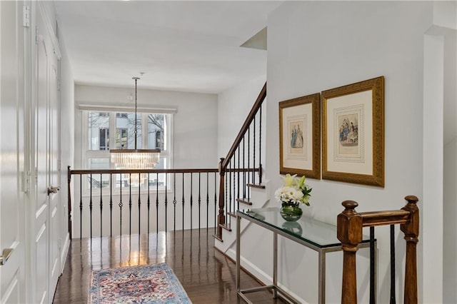 hallway featuring dark hardwood / wood-style floors and a notable chandelier