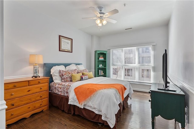 bedroom with dark hardwood / wood-style flooring and ceiling fan