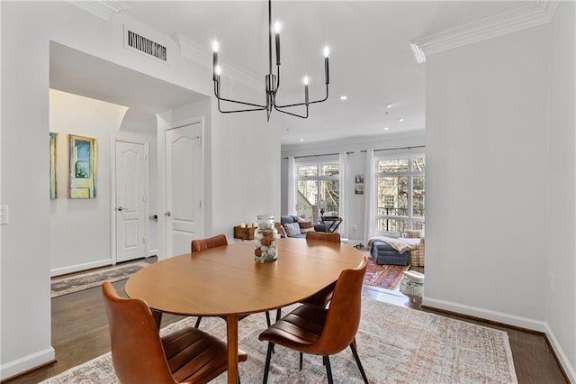 dining room featuring crown molding, dark hardwood / wood-style flooring, and a notable chandelier