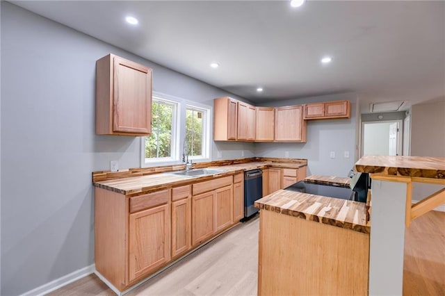 kitchen featuring stainless steel dishwasher, a sink, light brown cabinets, butcher block counters, and light wood-type flooring