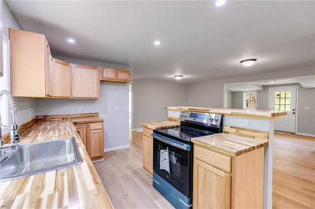 kitchen with electric stove, light brown cabinets, wooden counters, and a sink