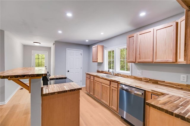 kitchen with a sink, dishwasher, butcher block countertops, and a kitchen island