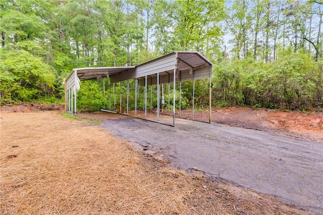 view of yard with driveway and a detached carport