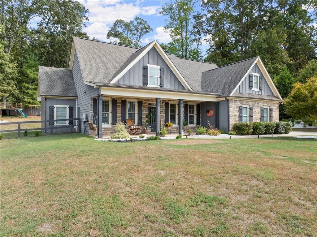 craftsman inspired home featuring covered porch and a front yard