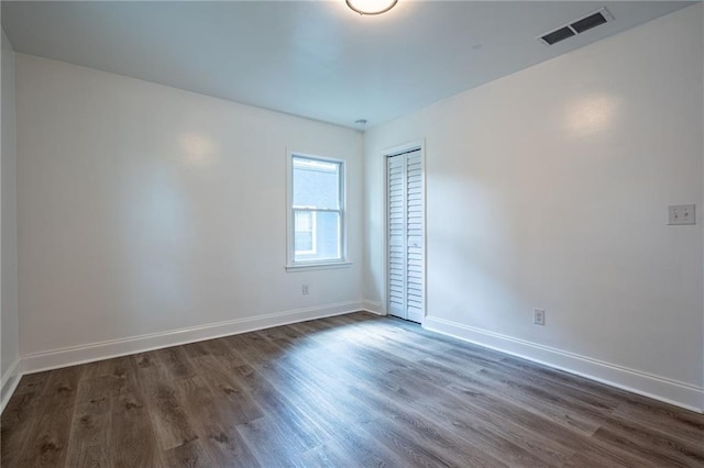 spare room with dark hardwood / wood-style flooring