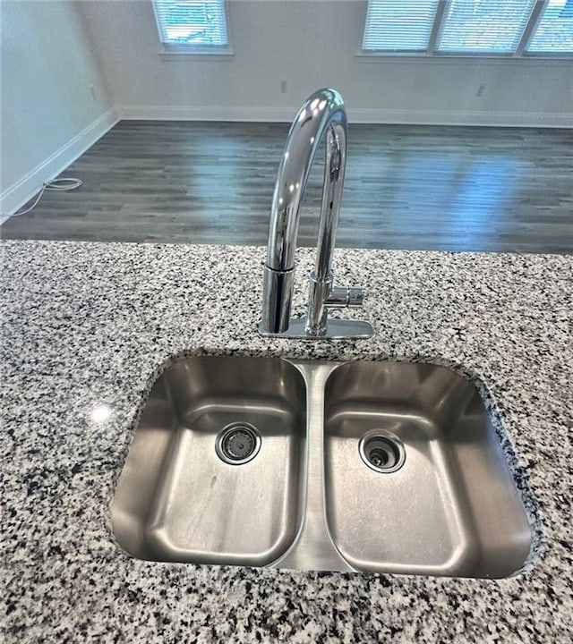 room details featuring stone countertops, dark hardwood / wood-style flooring, and sink