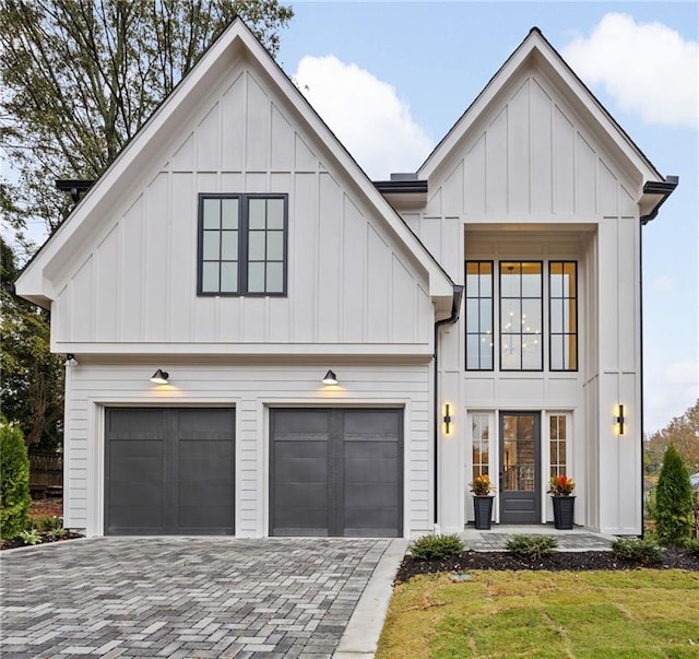 modern farmhouse featuring a garage and a front lawn