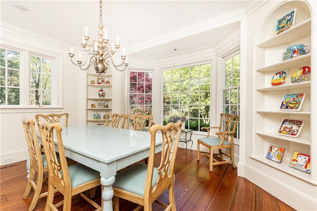 dining space with dark wood finished floors, an inviting chandelier, and built in shelves