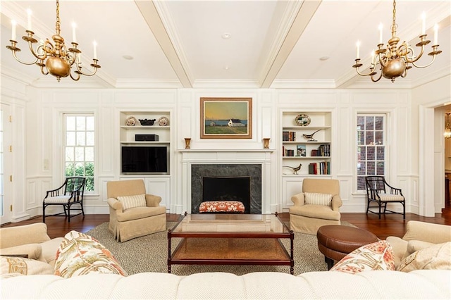 living room featuring built in shelves, a notable chandelier, beam ceiling, a decorative wall, and dark wood-style flooring