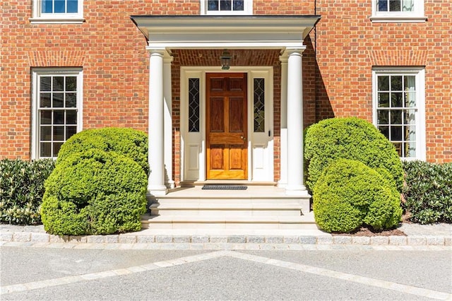 doorway to property featuring brick siding