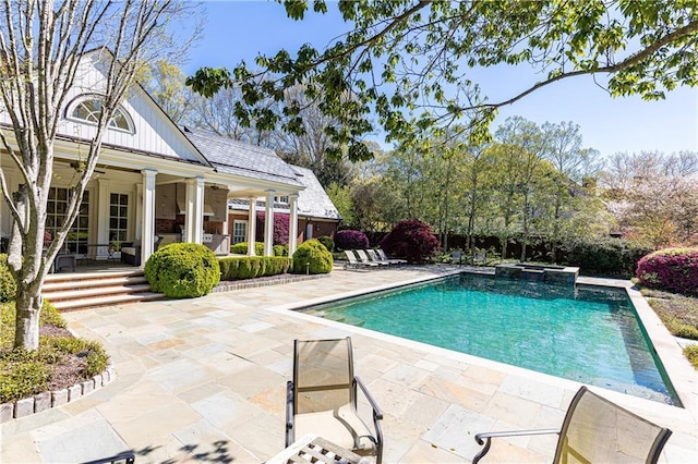 view of pool featuring a patio, ceiling fan, and a pool with connected hot tub