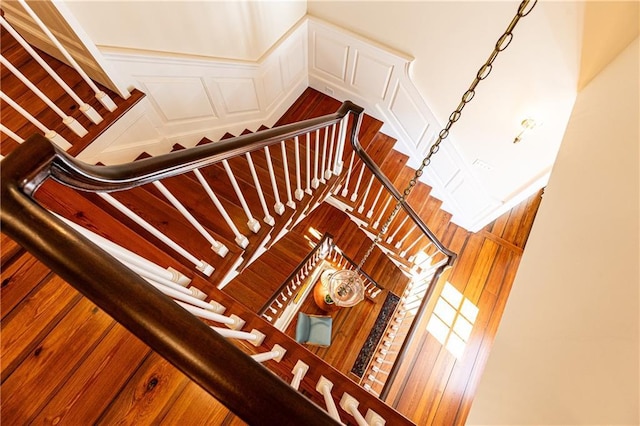 stairs with a decorative wall and a wainscoted wall