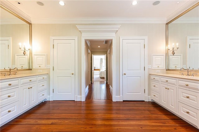 bathroom with crown molding, baseboards, recessed lighting, vanity, and wood-type flooring