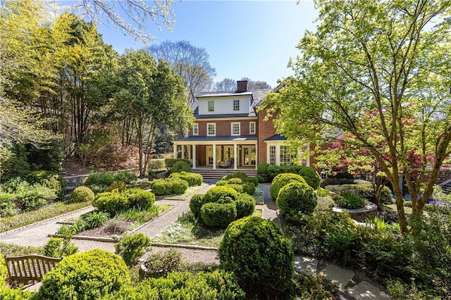 back of property featuring a porch and a chimney