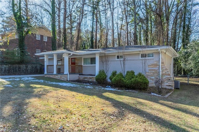 view of front facade with a front lawn, a porch, and cooling unit