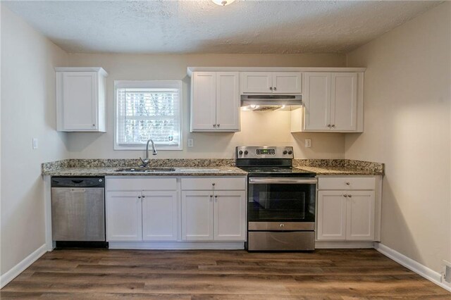 kitchen featuring a textured ceiling, white cabinetry, stainless steel appliances, sink, and light stone counters