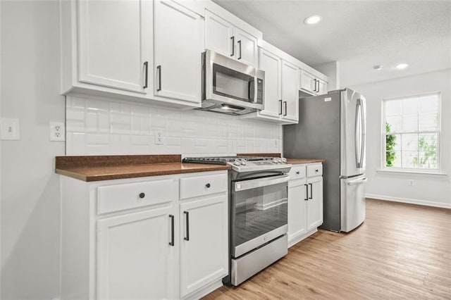 3454 Carriage Chase Rd, Atlanta, GA 30349 - kitchen with stainless steel appliances, dark countertops, tasteful backsplash, white cabinets, and recessed lighting