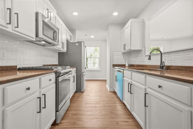 3454 Carriage Chase Rd, Atlanta, GA 30349 - kitchen with stainless steel appliances, dark countertops, healthy amount of natural light, light wood finished floors, and recessed lighting