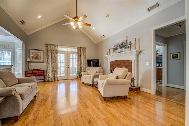 living room featuring healthy amount of natural light, light wood-style flooring, a ceiling fan, high vaulted ceiling, and ornamental molding