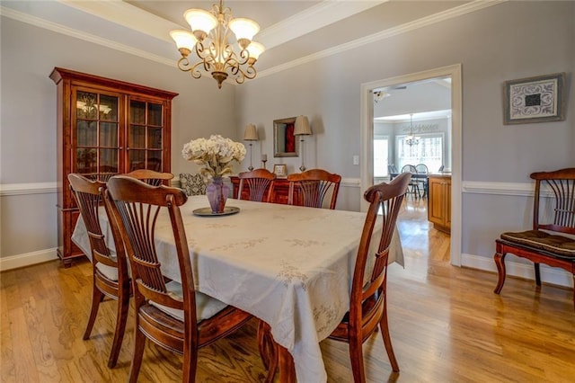 dining room with a chandelier, light wood-style floors, ornamental molding, and baseboards