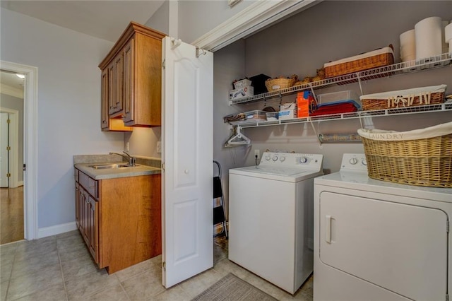laundry room with washer and clothes dryer, light tile patterned flooring, and baseboards