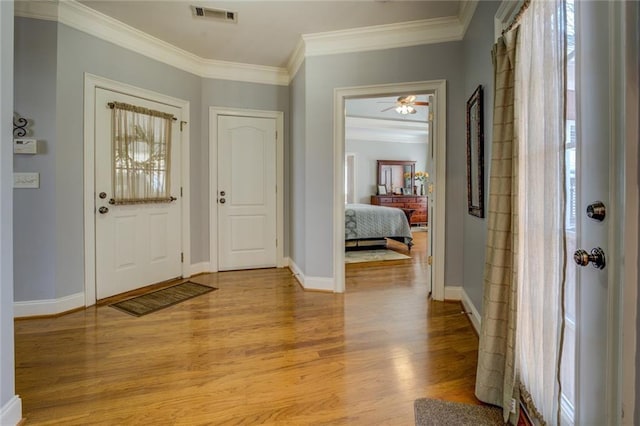 entrance foyer featuring light wood-type flooring, ornamental molding, baseboards, and ceiling fan