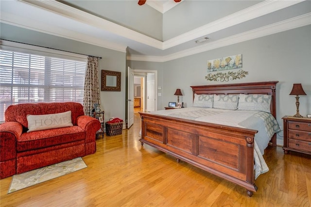 bedroom featuring light wood finished floors, crown molding, and ceiling fan