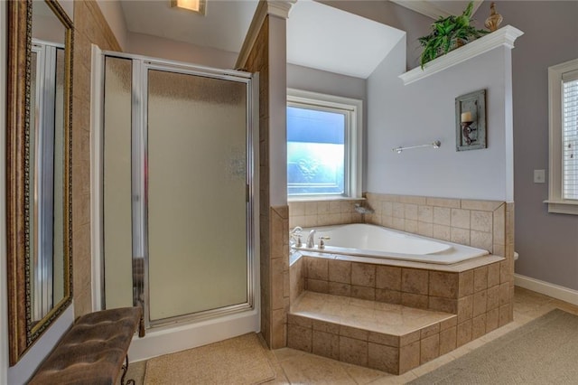 bathroom with a shower stall, a bath, baseboards, and tile patterned floors