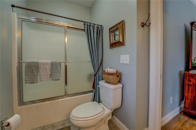 full bath with shower / bath combination with glass door, toilet, baseboards, and wood finished floors