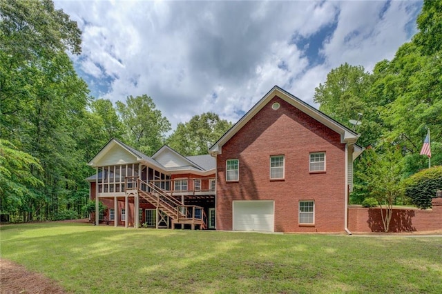 back of house with a sunroom, brick siding, a garage, a yard, and stairway