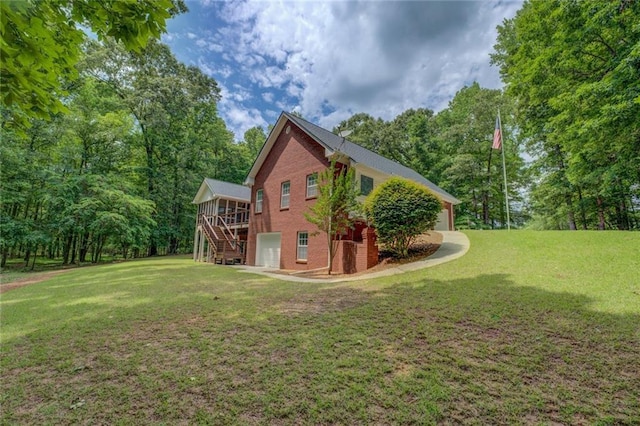 view of home's exterior with stairs, an attached garage, brick siding, and a lawn