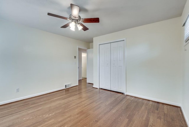 unfurnished bedroom with light wood-type flooring, ceiling fan, and a closet