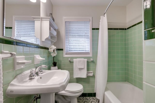 full bathroom featuring sink, tile walls, toilet, and shower / bath combination with curtain