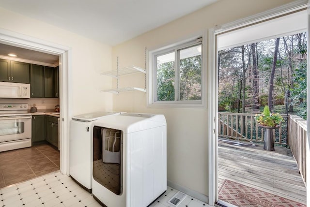 laundry room with light tile patterned flooring and washing machine and clothes dryer