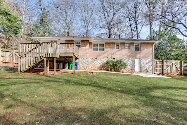 back of house featuring a lawn and a wooden deck