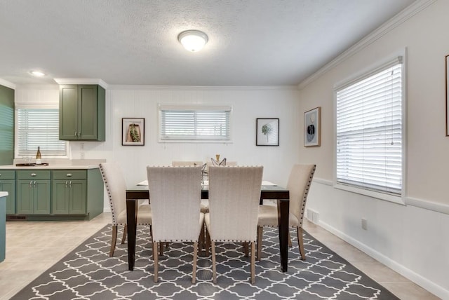 dining space featuring a healthy amount of sunlight, light tile patterned floors, and crown molding