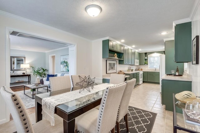 tiled dining area with sink, a textured ceiling, and crown molding