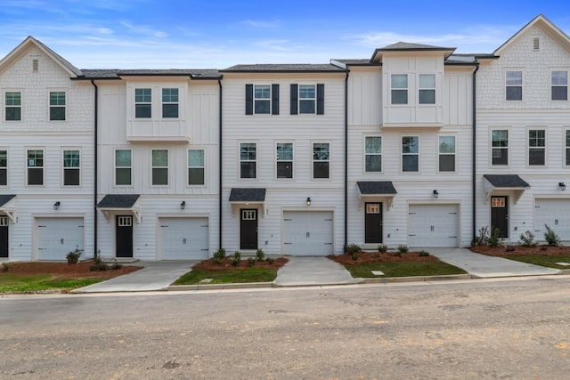 multi unit property with driveway, an attached garage, and board and batten siding