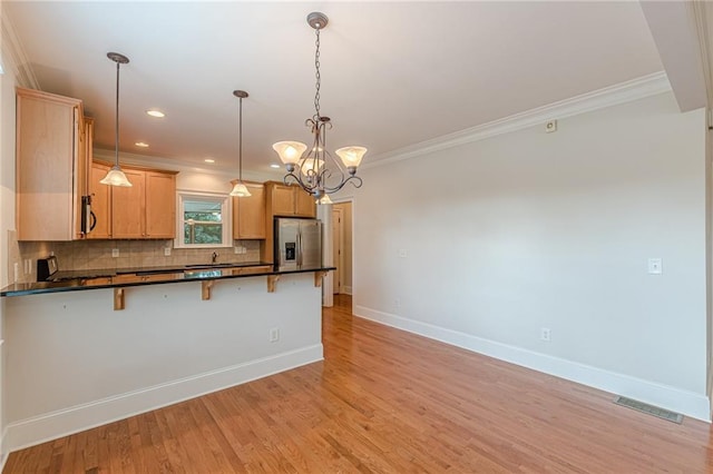 3404 Orchard St, Hapeville, GA 30354 - kitchen featuring stainless steel fridge, dark countertops, a kitchen bar, crown molding, and a peninsula