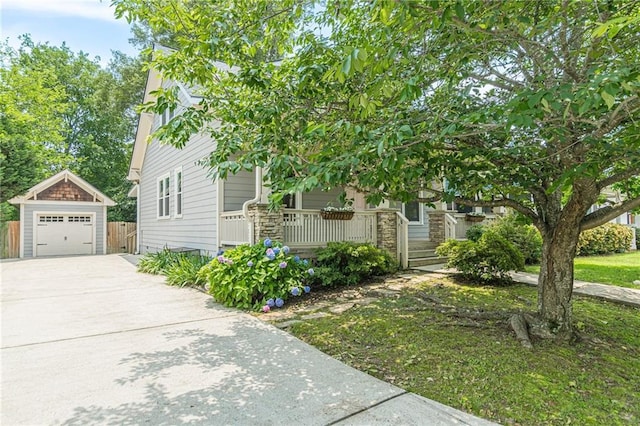 3404 Orchard St, Hapeville, GA 30354 - view of property hidden behind natural elements with covered porch, driveway, a detached garage, and an outbuilding