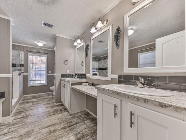 bathroom with decorative backsplash, vanity, a textured ceiling, hardwood / wood-style floors, and toilet