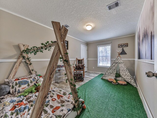 bedroom with a textured ceiling, carpet floors, and crown molding